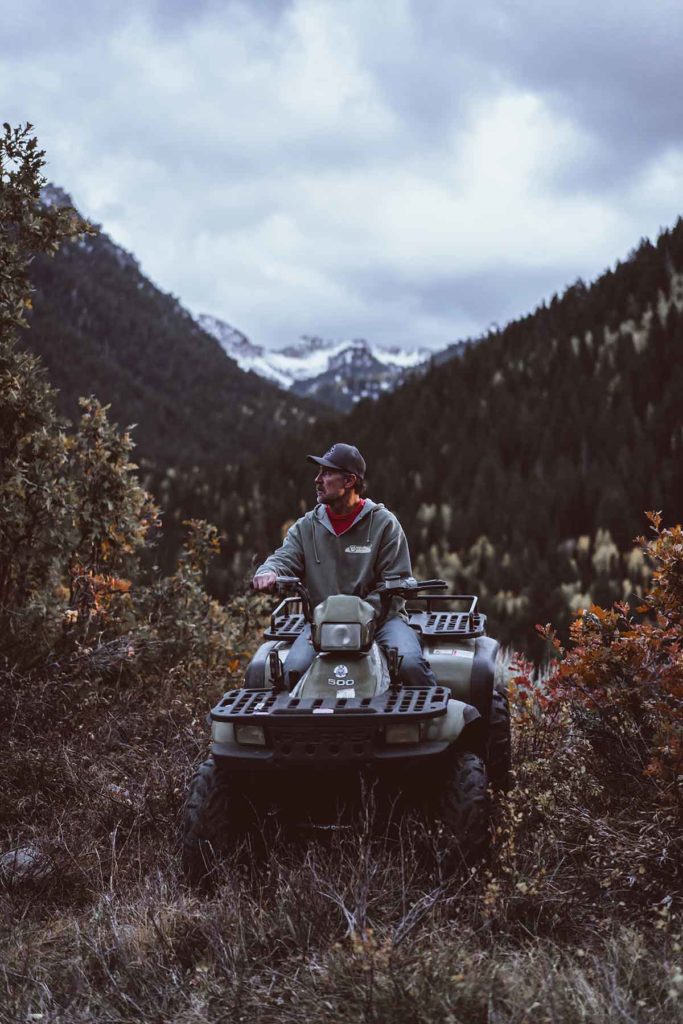 Man on ATV in forested mountains