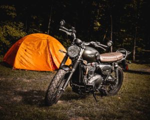 Triumph motorcycle parked at tent campsite